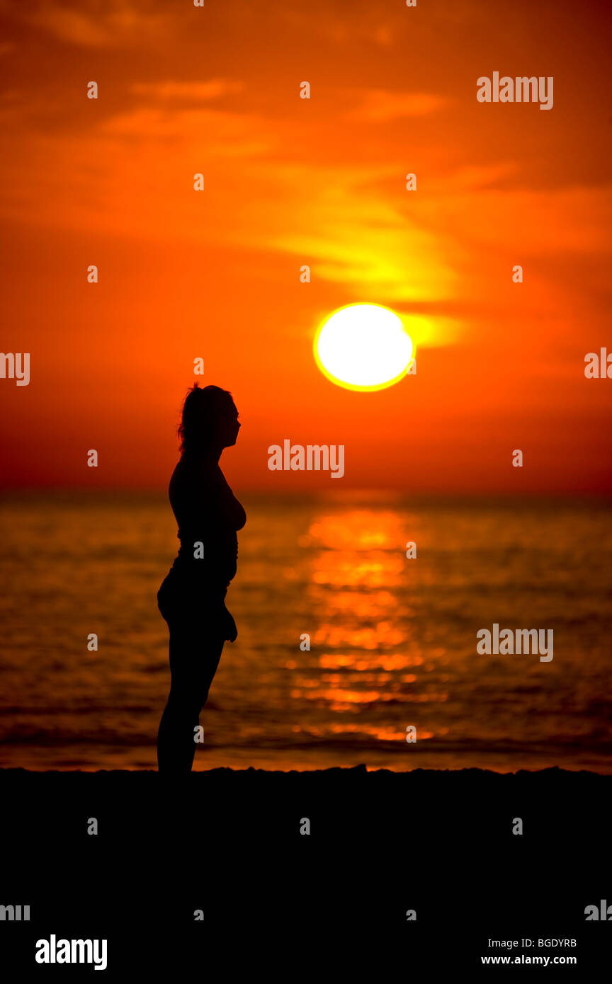 Silhouette of a girl watching the sunset at Ft. Desoto looking over the ...