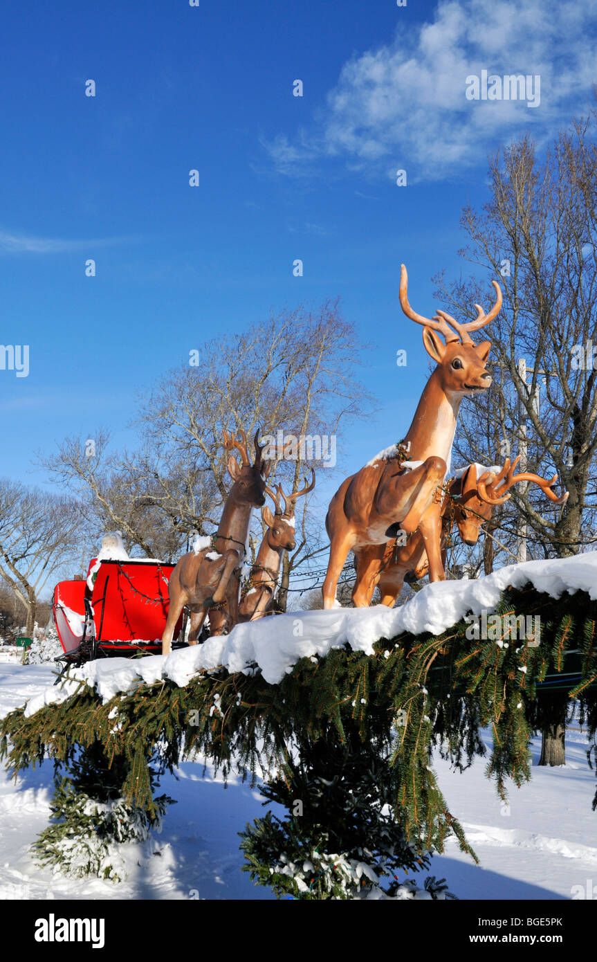 Christmas display with reindeer pulling Santa Claus in red sleigh in Falmouth Cape Cod Stock Photo