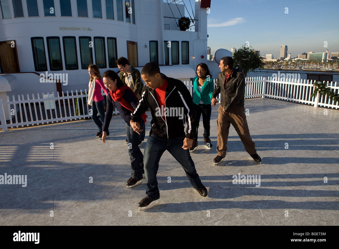 Friends ice skating on a synthetic ice rink aboard the Queen Mary in