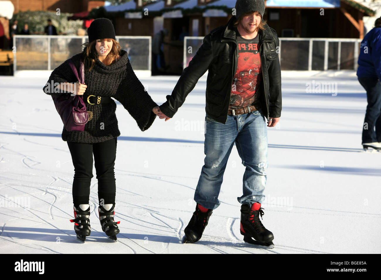 Young Adult man and woman ice skating at an outdoor rink Stock Photo