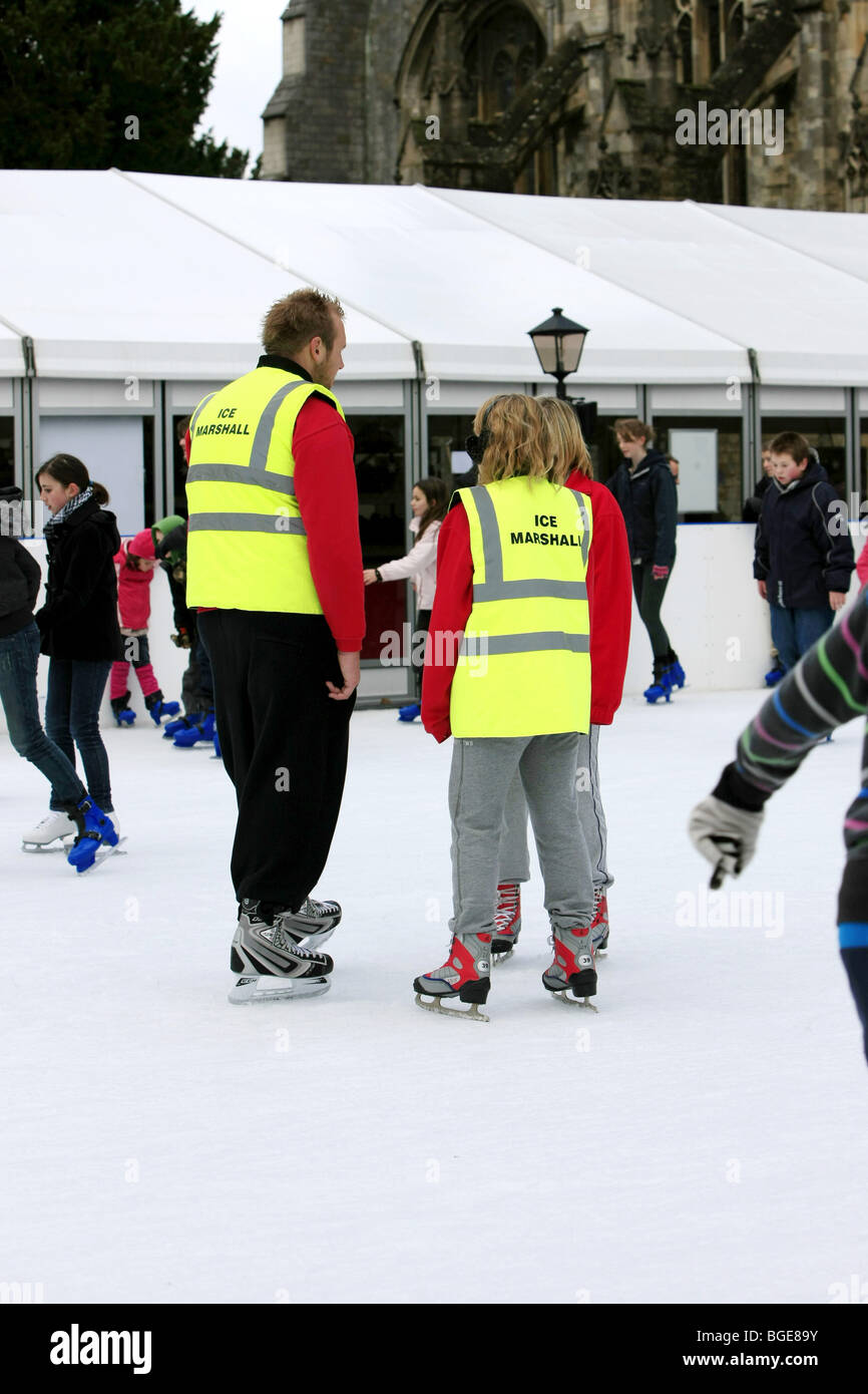 Ice Marshalls keep a watch on people ice skating at an outdoor rink Stock Photo