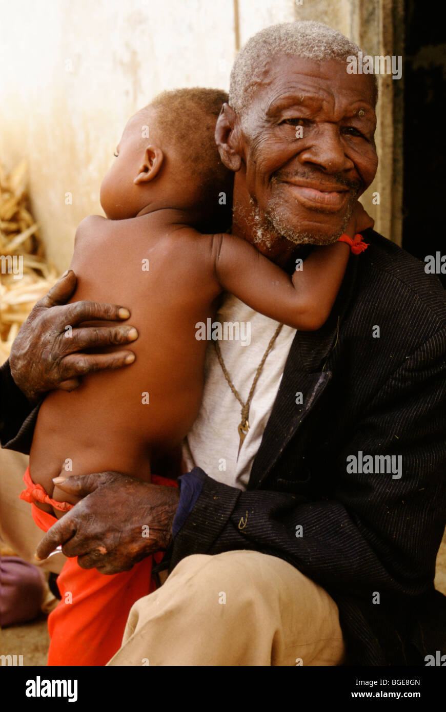 A resident in a leper colony, Luanda, Angola, holds his young son Stock Photo