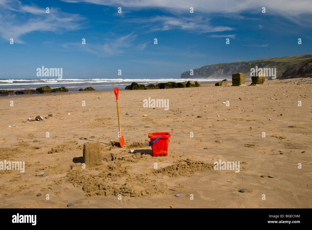 Typical summer beach scene on the sand a Filey Beach with Bempton Cliffs in the background. Stock Photo