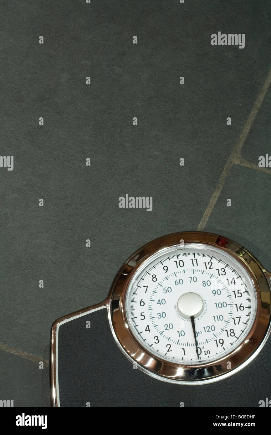 Weighing scales on a slate floor with copyspace Stock Photo