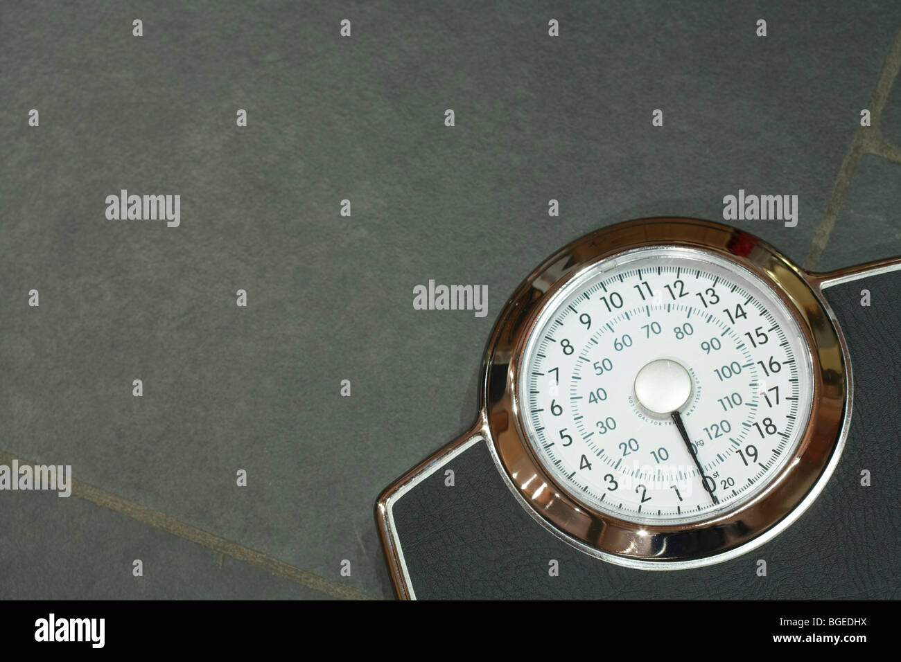 Bathroom scales on a slate floor with copyspace Stock Photo