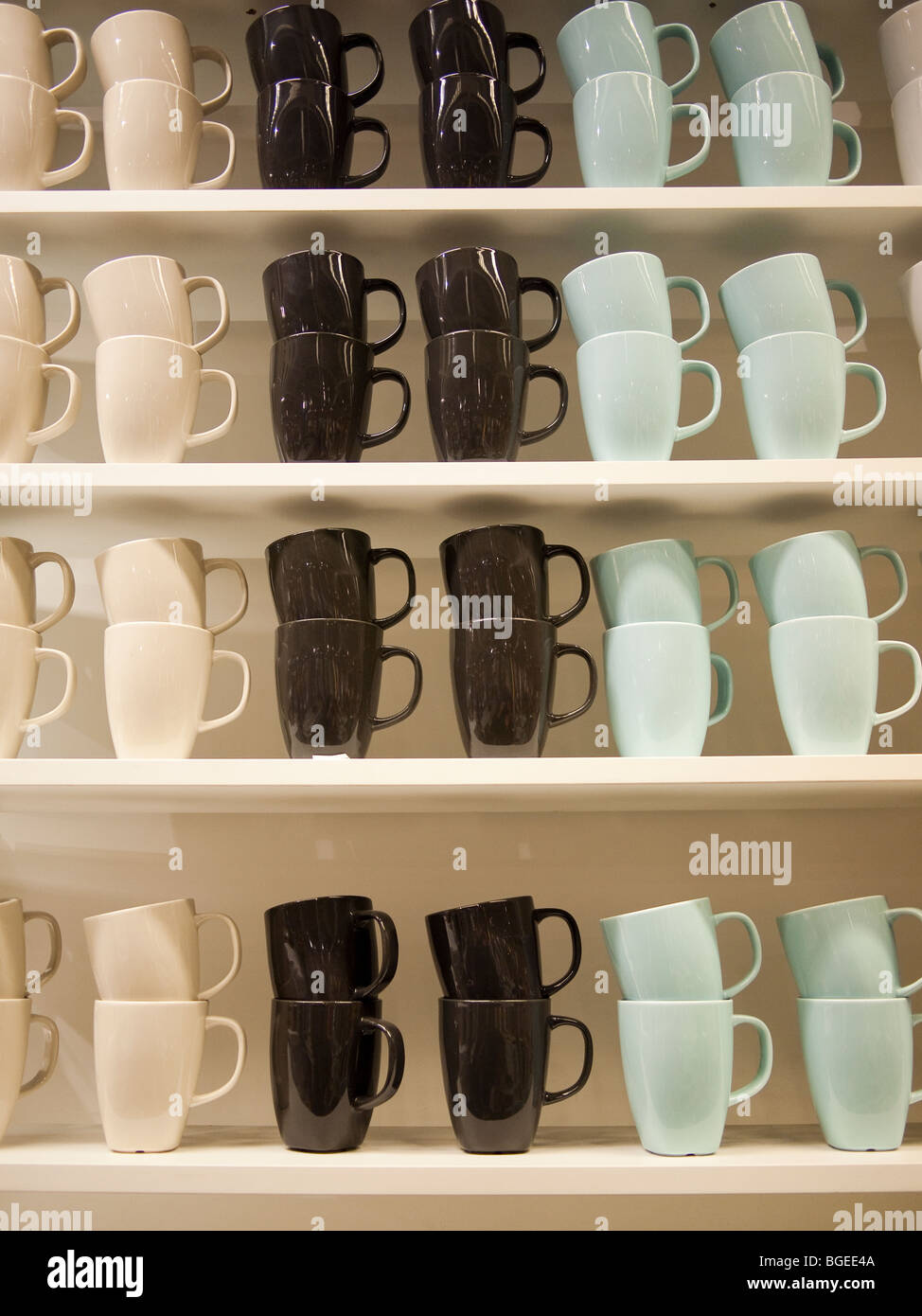 Rows of coloured cups on shelves Stock Photo