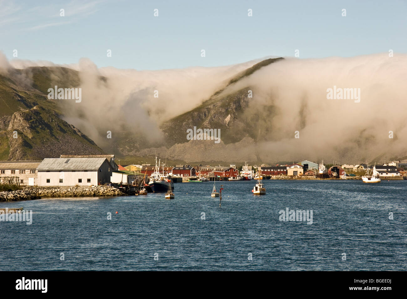 Fog swirls into the harbor of the fishing village of Vaeroy in Northern Norway Stock Photo