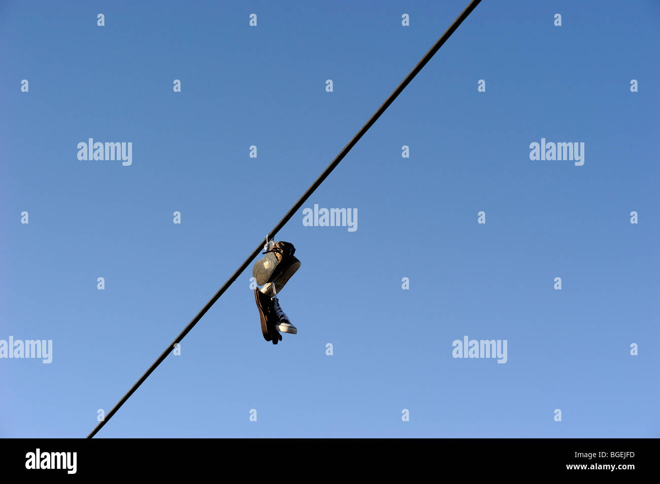 Shoes hanging from power line Stock Photo - Alamy