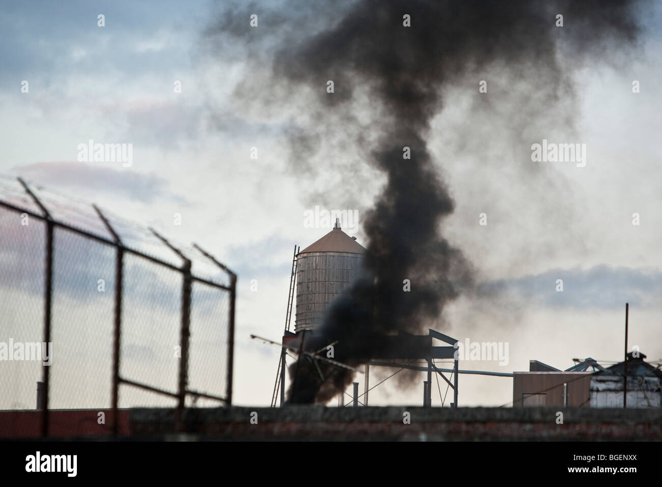 Black smoke belches out into the sky from the roof top of a building on West 143rd street in New York, USA, 28 December 2009. Stock Photo