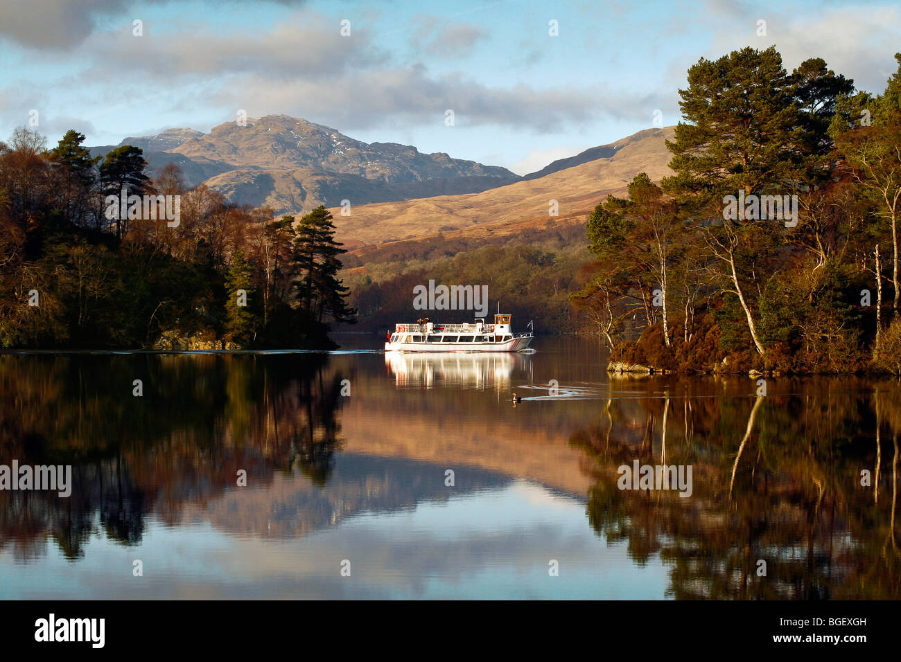 A tourist boat crosses Loch Katrine on a beautiful winters day Stock Photo