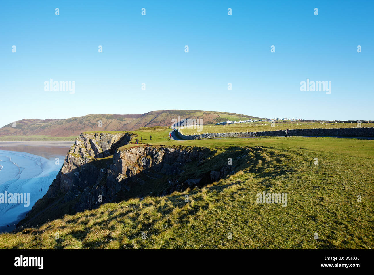 Ramblers walking along the footpath towards Worms Head, Rhossili, the Gower Peninsular, South Wales, UK Stock Photo