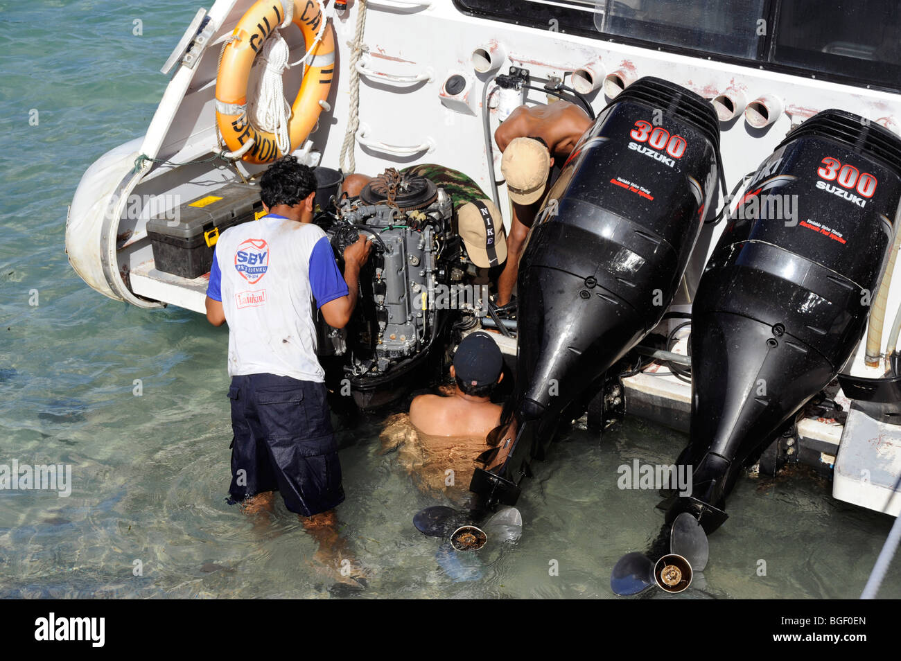 Mechanics take down the motor boat on the Padang Bai beach, Bali, Indonesia Stock Photo