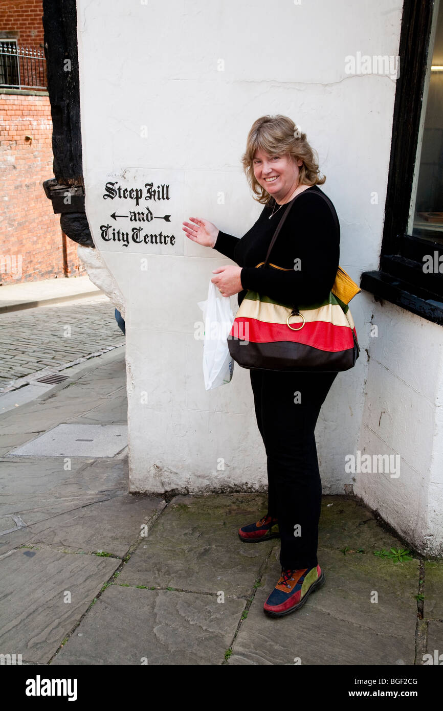 Woman pointing at sign for Steep Hill and City Centre, Lincoln Stock Photo