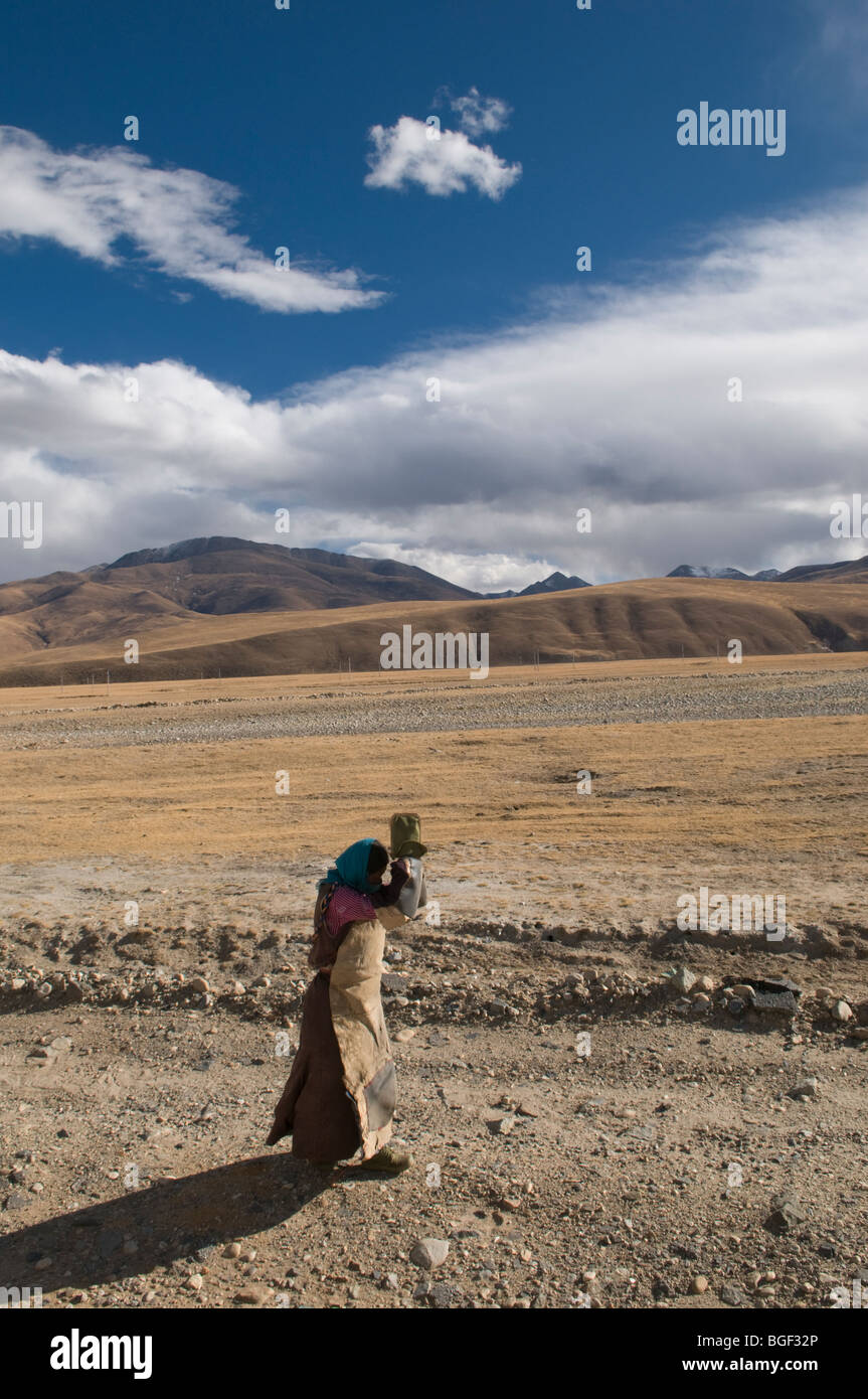 A devout Tibetan pilgrim prostrates along the high plateau  of Tibet on her way to the Jokhang temple in Lhasa. Stock Photo