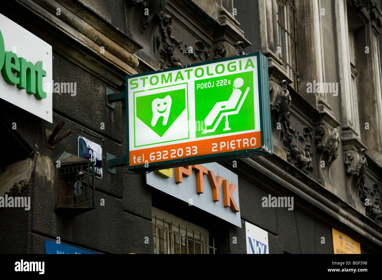 Street sign for a dentist / dental / dentristy  business offering treatment or repairs at a surgery / office in Krakow, Poland. Stock Photo