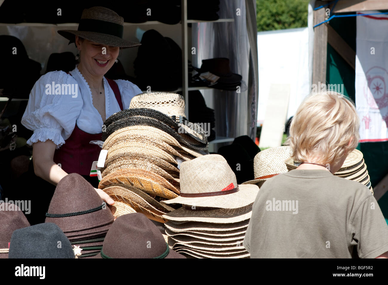 Young boy trying on straw hats in Germany Stock Photo