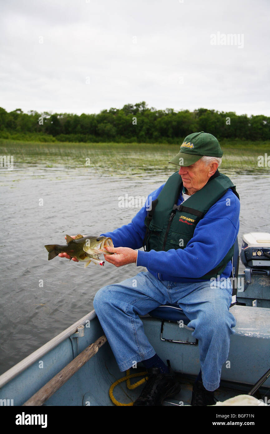 Close up fisherman holding large mouth bass with heddon chugger spook lure in mouth XRW540 Stock Photo