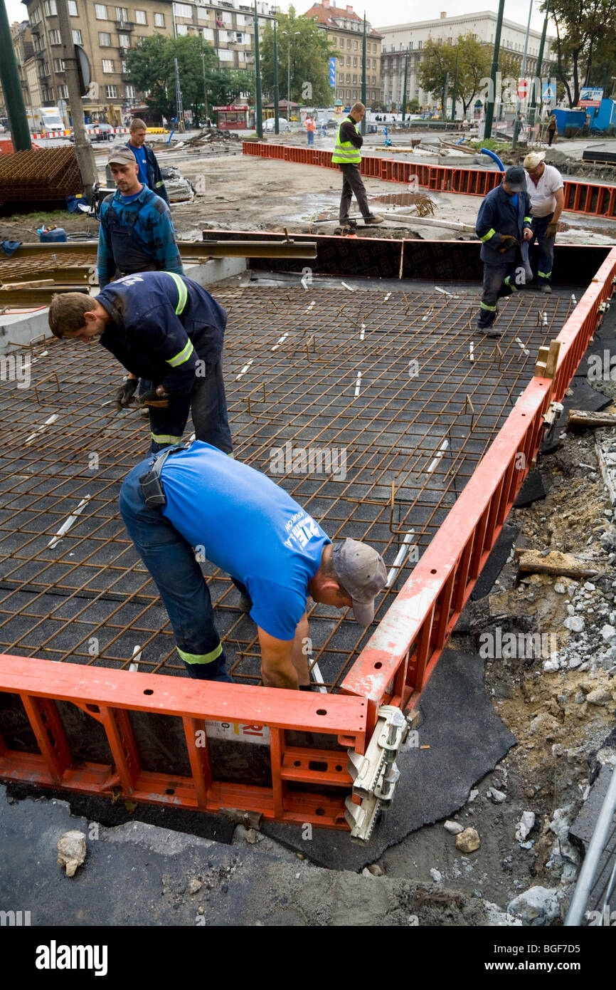 Polish construction workers prepare to lay reinforced concrete for new tram tracks a road site in Krakow town centre. Poland. Stock Photo