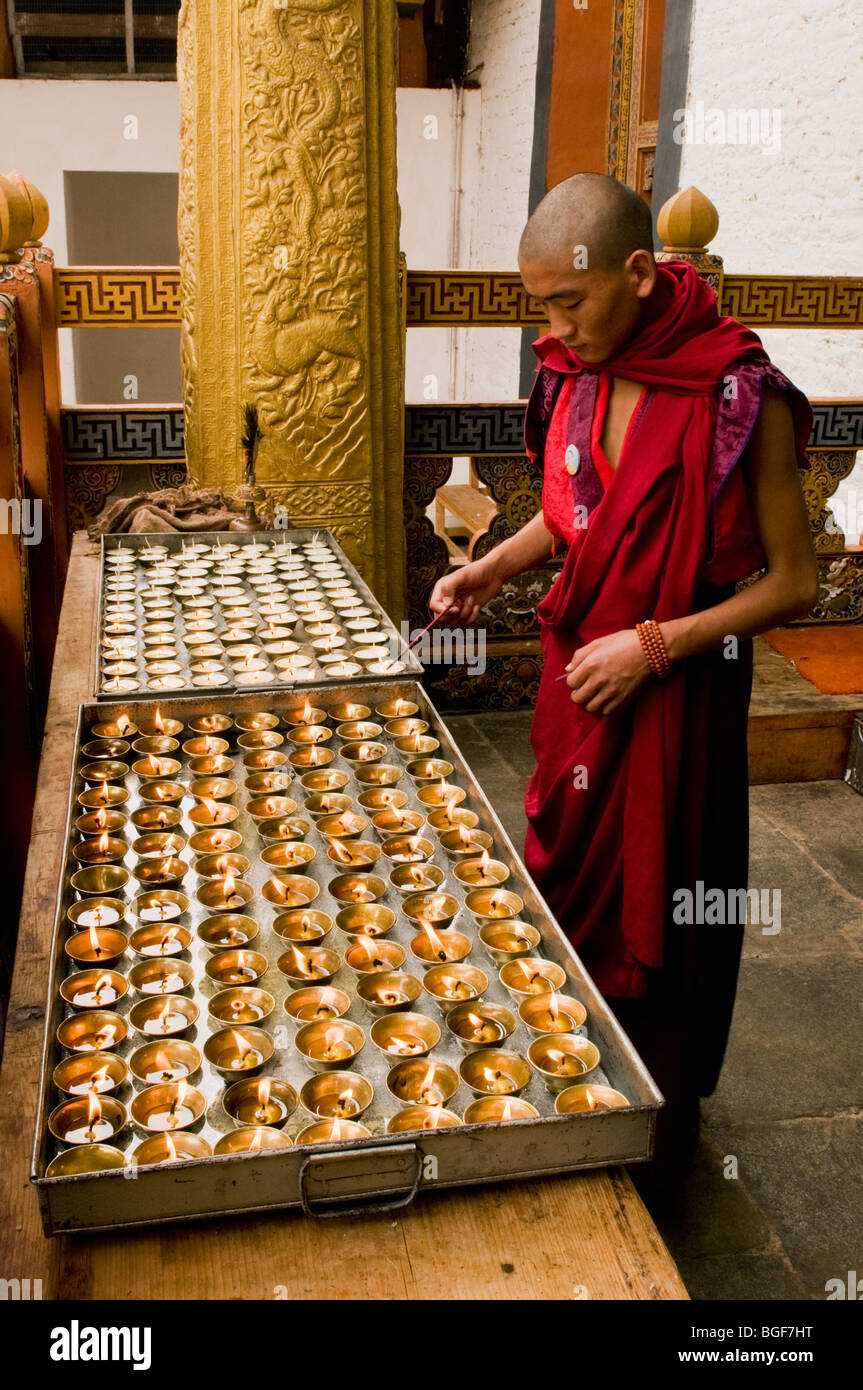 Buddhist Monk lighting candles, Punakha Dzong Monastery, BHUTAN Stock Photo