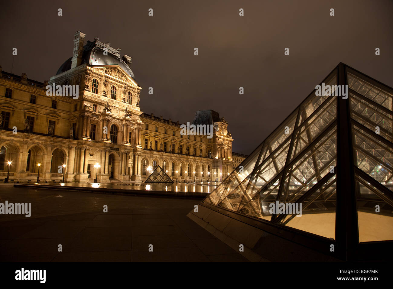 Louvre Museum and Triangle Pyramid lit up at night Stock Photo