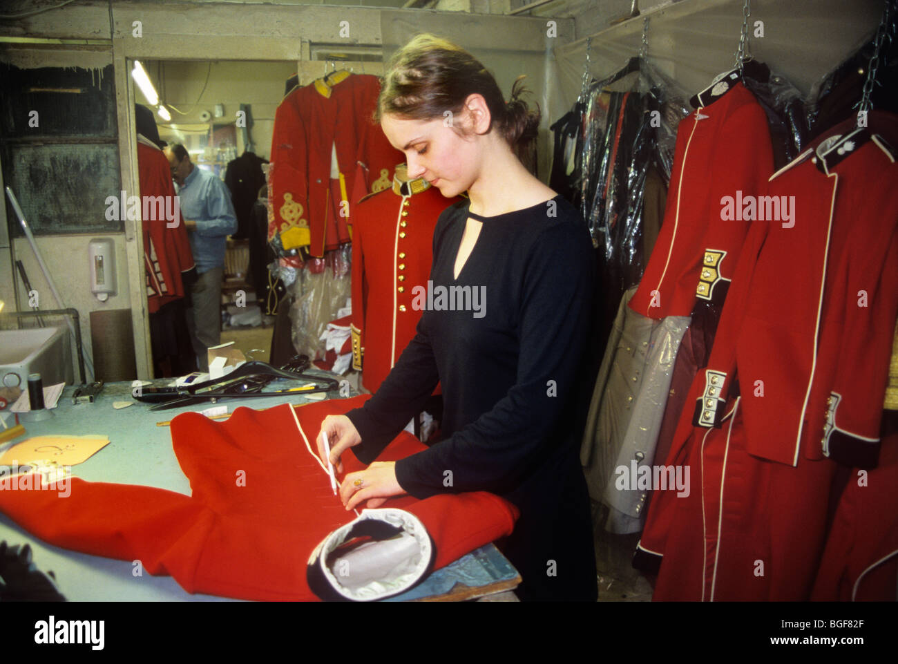 Seamstress working on a military uniform being produced by a company of