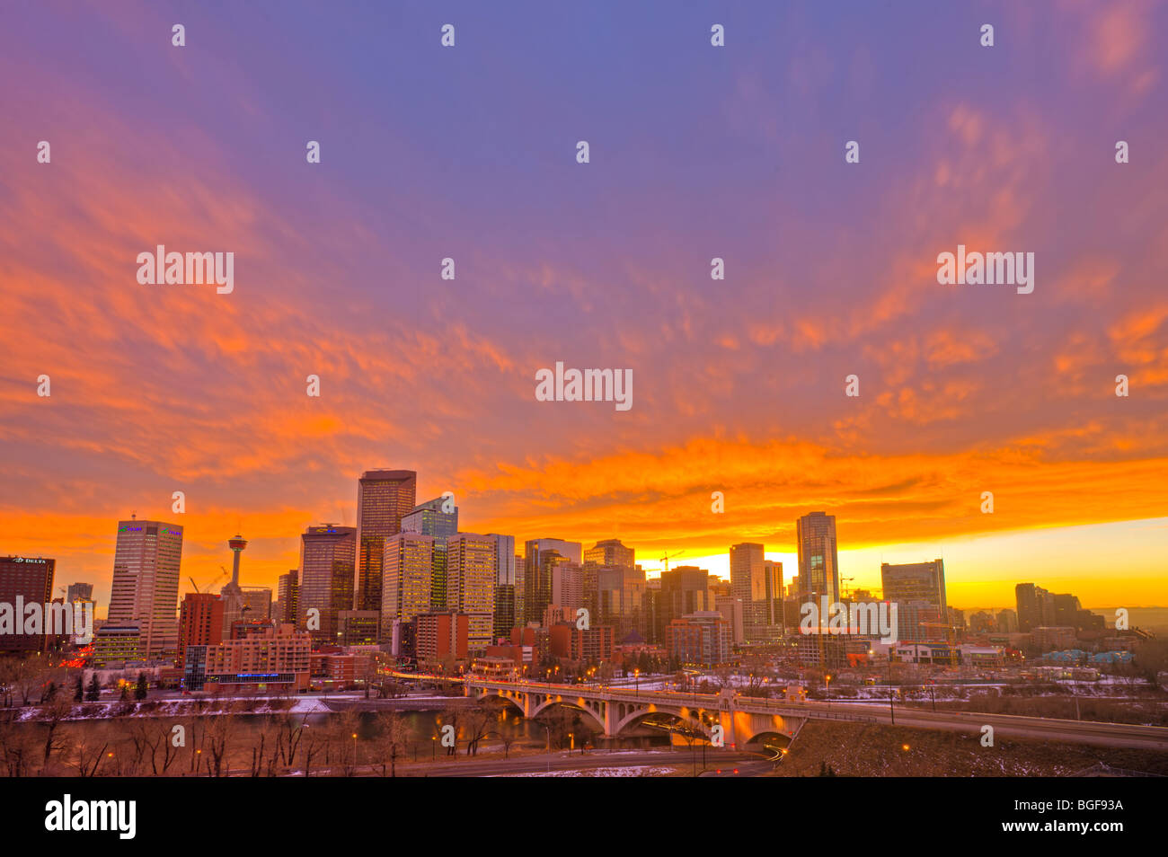 Calgary skyline of high-rise buildings, the Calgary Tower, and the Centre Street Bridge spanning the Bow River at sunset after l Stock Photo
