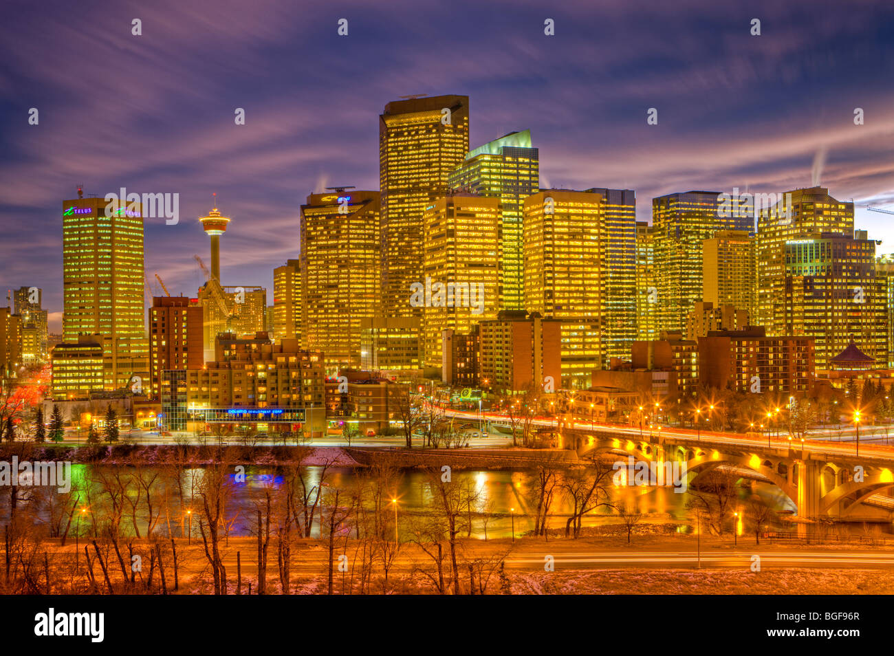 Calgary skyline of high-rise buildings, the Calgary Tower, and the Centre Street Bridge spanning the Bow River at dusk after lig Stock Photo