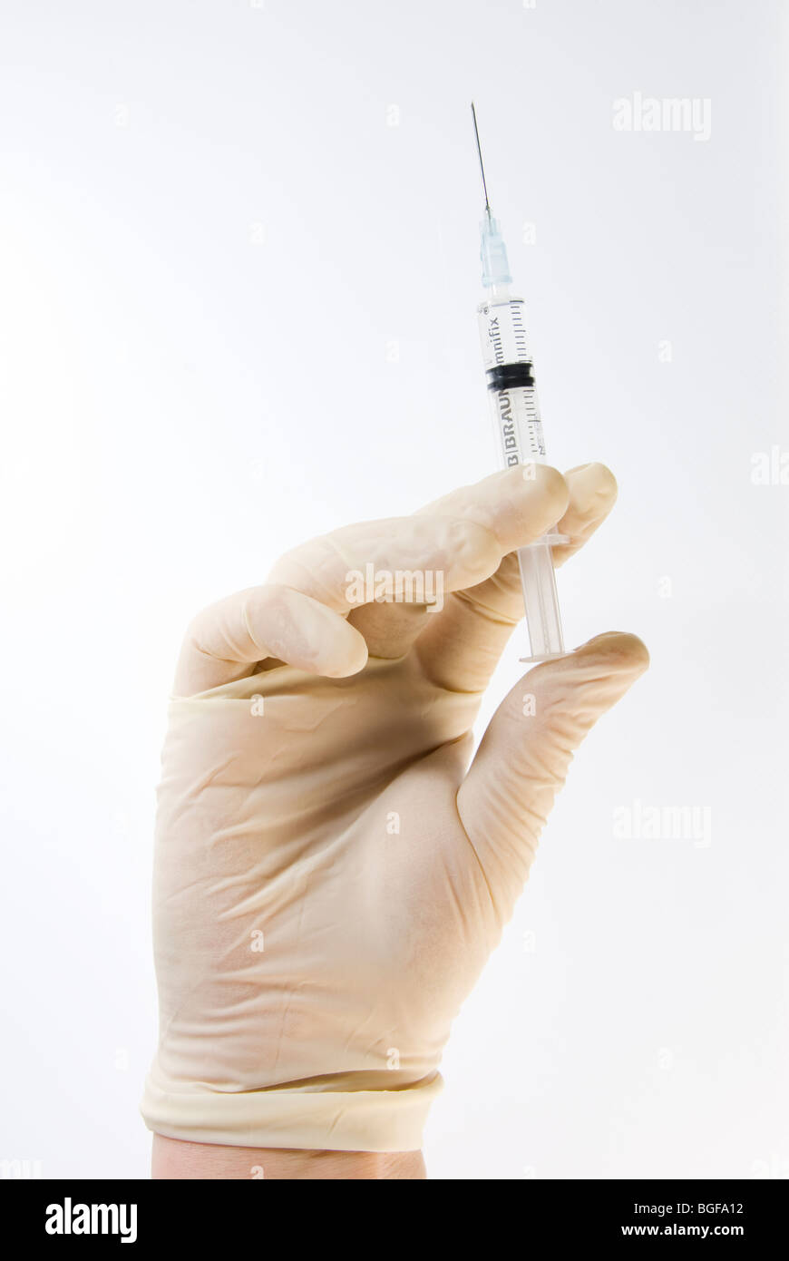 Gloved Hand Holding Hypodermic Needle Syringe Isolated on White Stock Photo