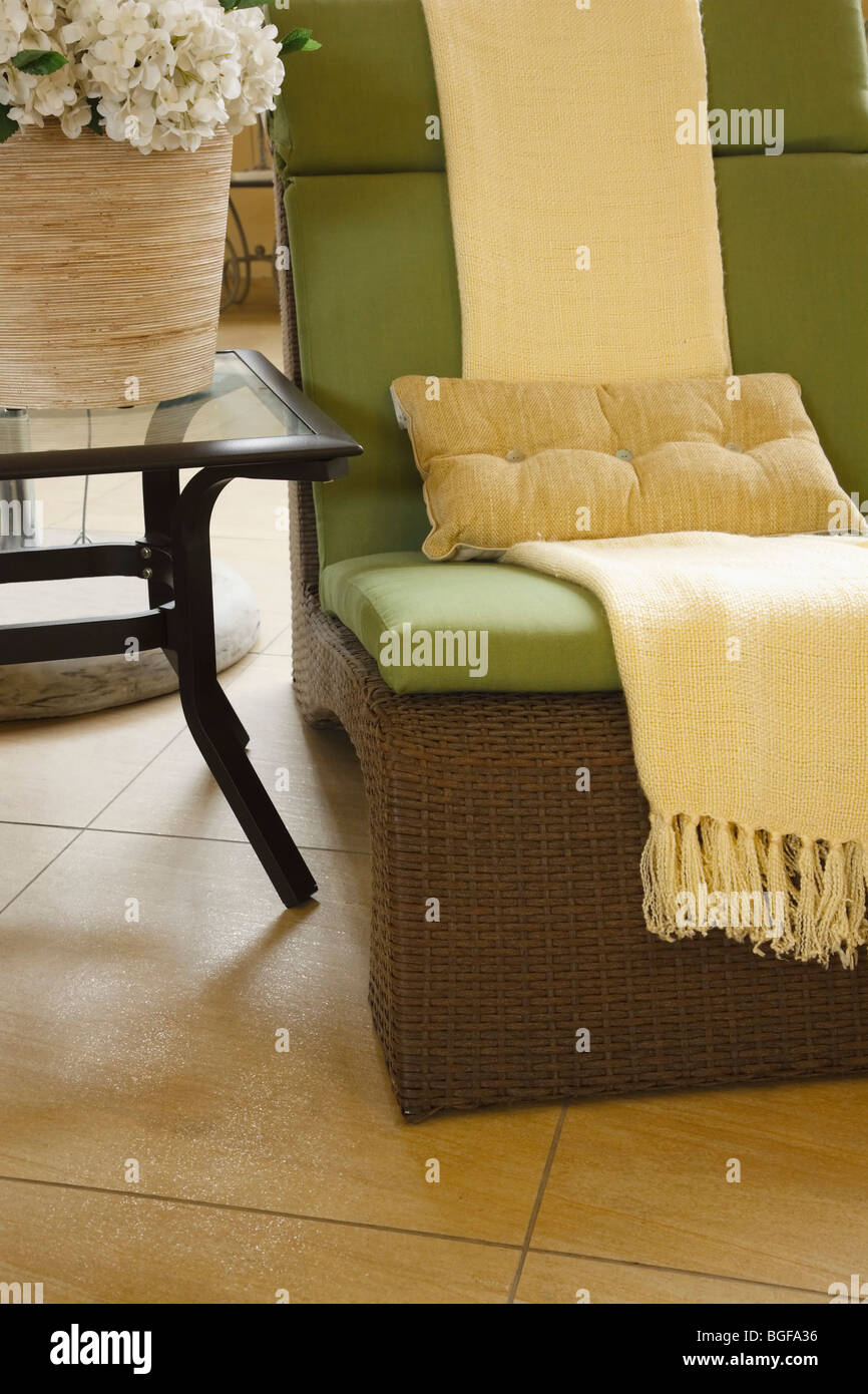 Modern decor. Cane chair and steel side table on tiled floor. Color Stock Photo Alamy