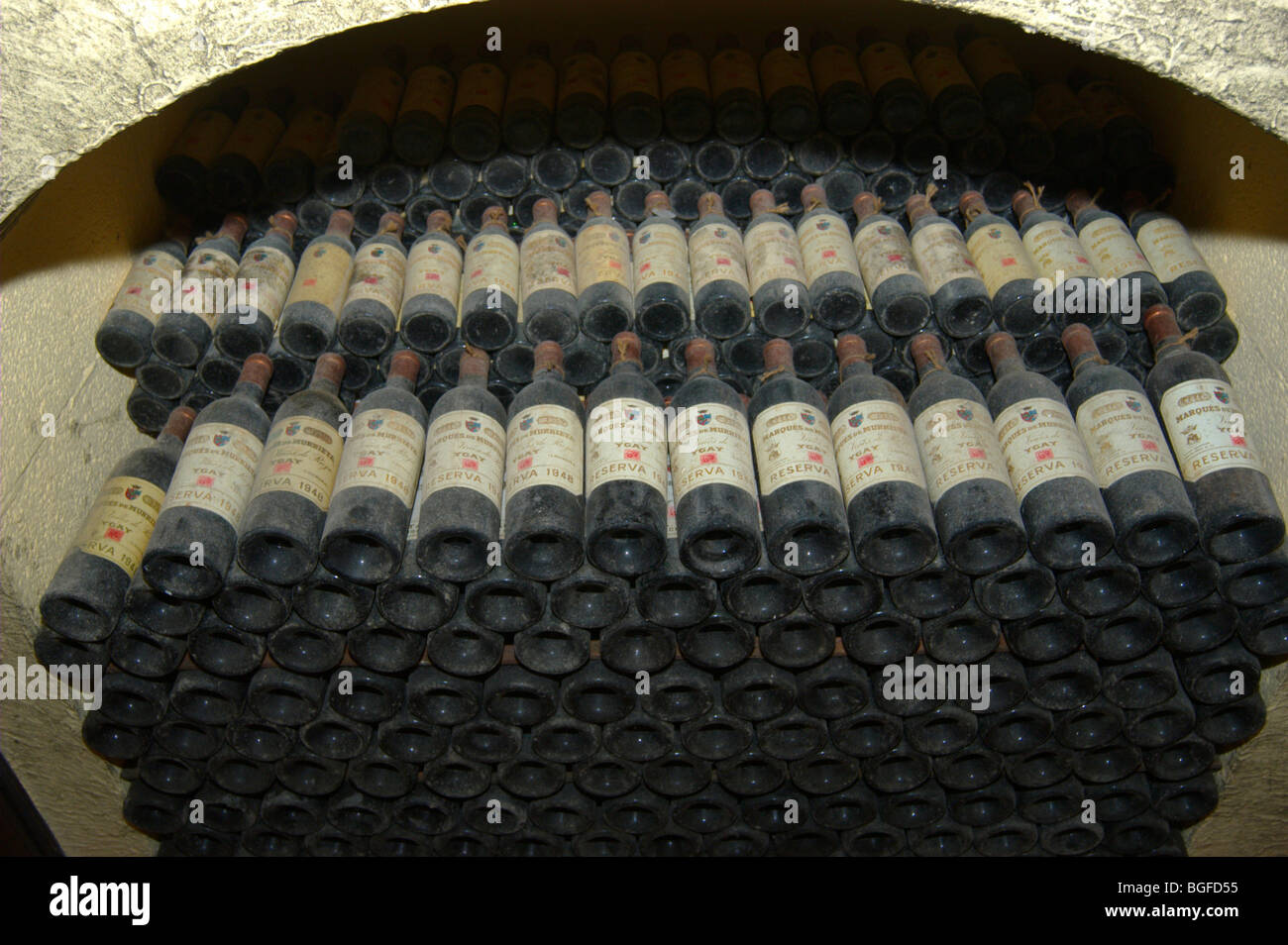 Stacks of vintage Rioja bottles ageing in a wine cellar in Spain. Stock Photo