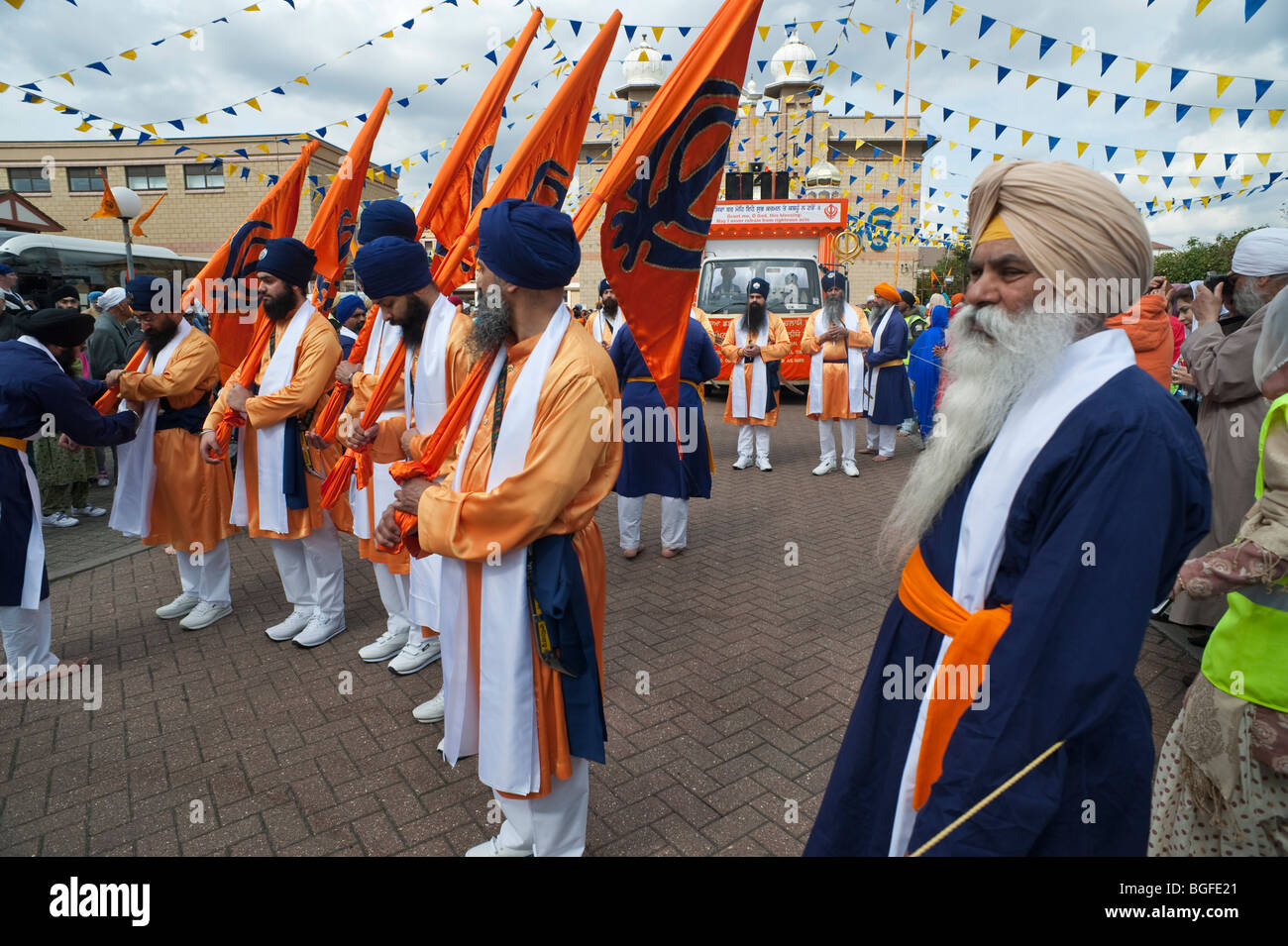 Khalsa with Sikh flags (Nisan Sahib) carrying the Khanda symbol line up for the start of the Vaisakhi procession Stock Photo