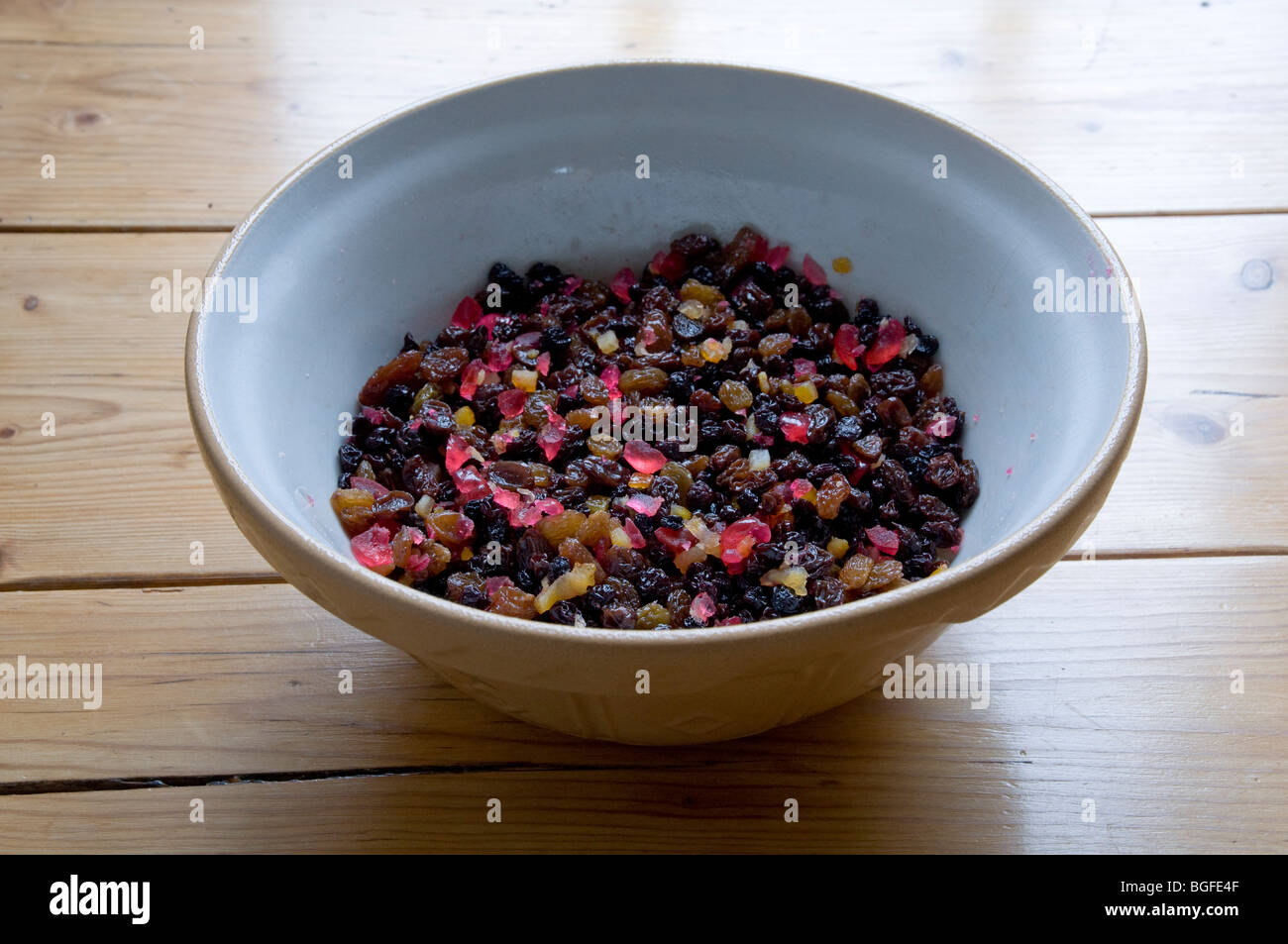 Dried fruit mix, including jewel like red glace cherries - soaked in brandy - ready for the Christmas cake, pud or mincepies. Stock Photo