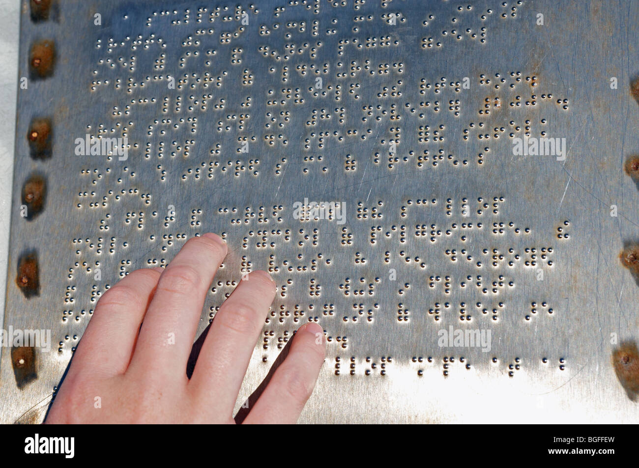 Blind woman reading a tourist information board written in braille