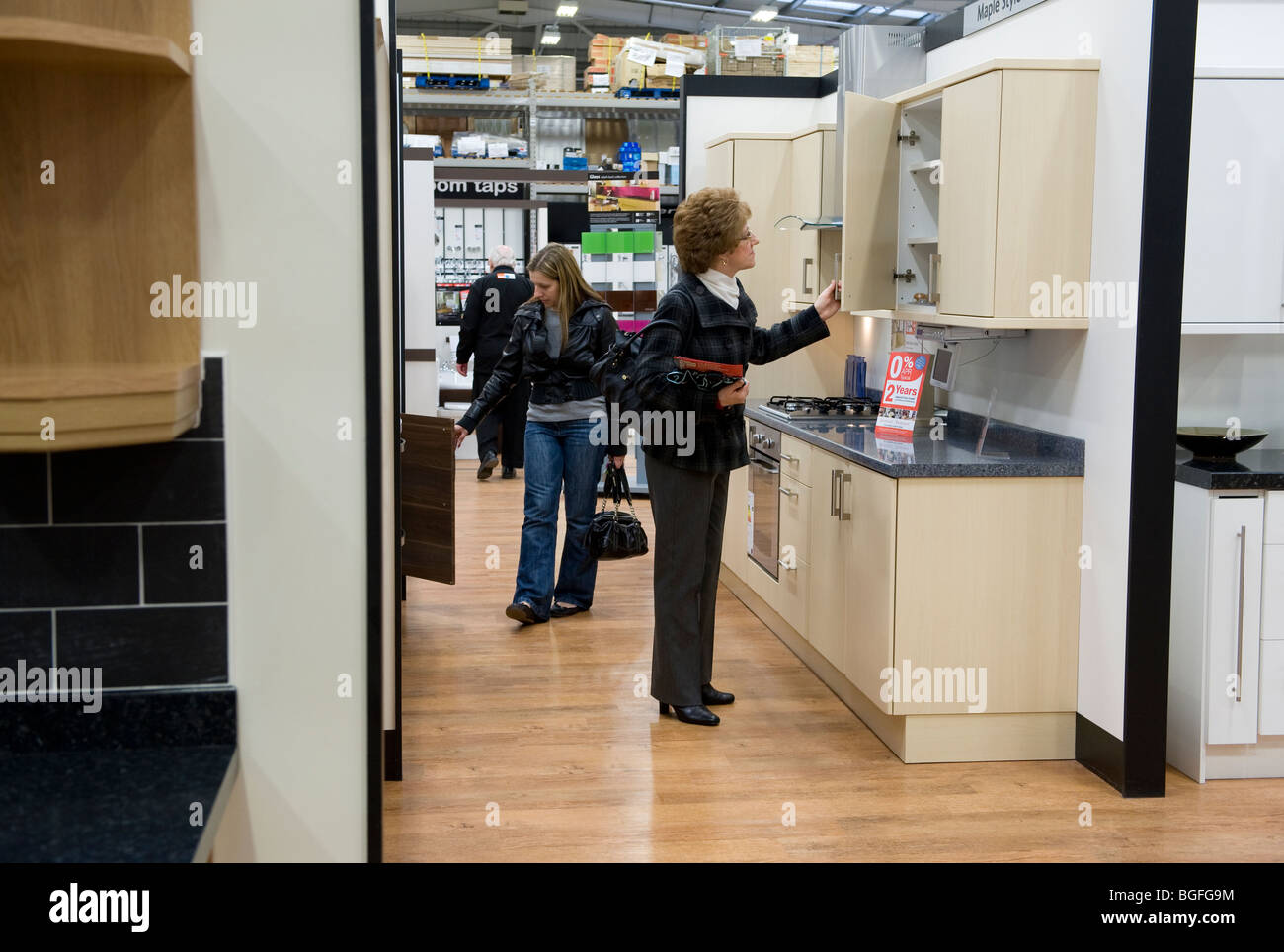 A Woman Looks At Kitchen Units In A Diy Superstore Stock Photo