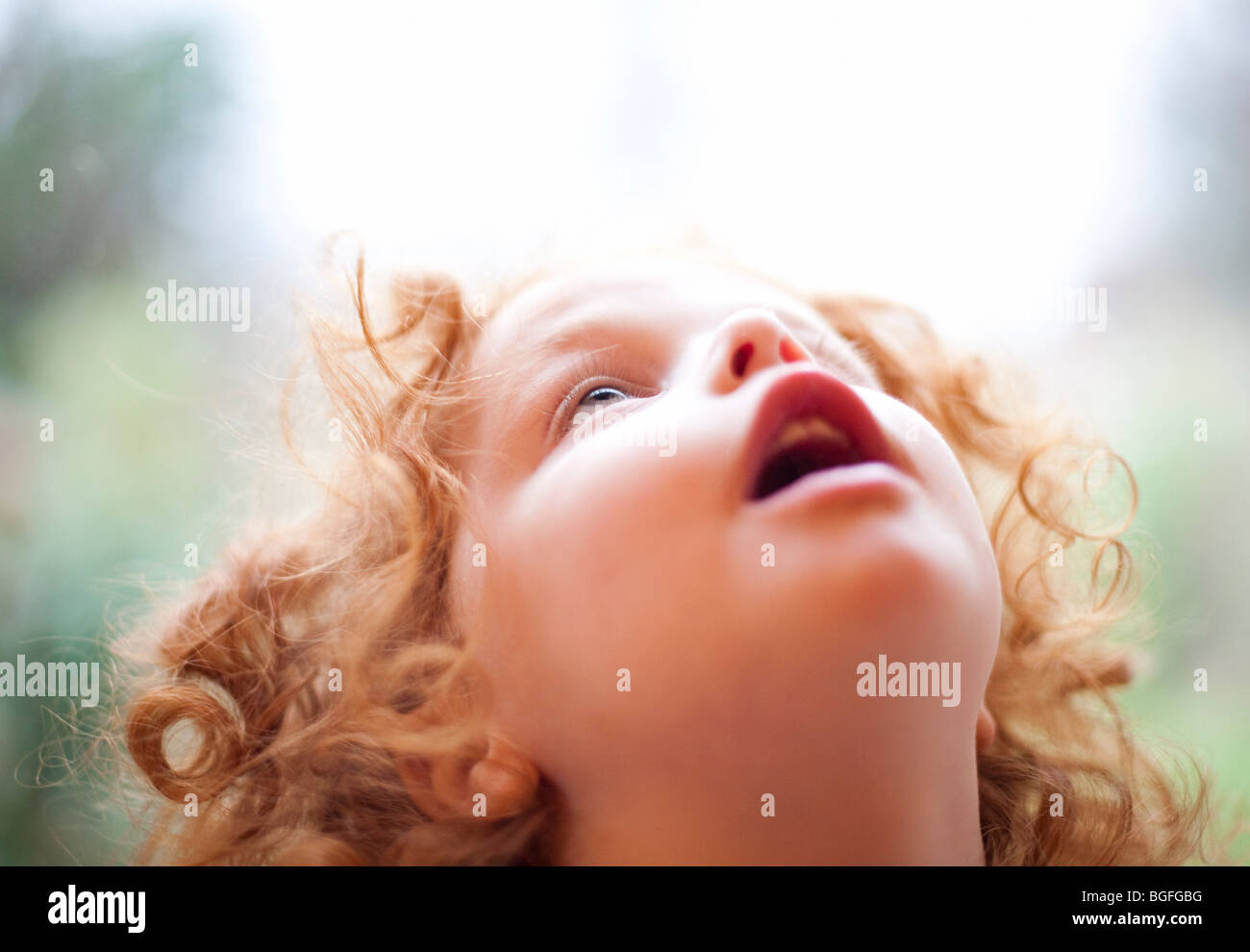 A three year old girl looking in wonder at the sky above Stock Photo