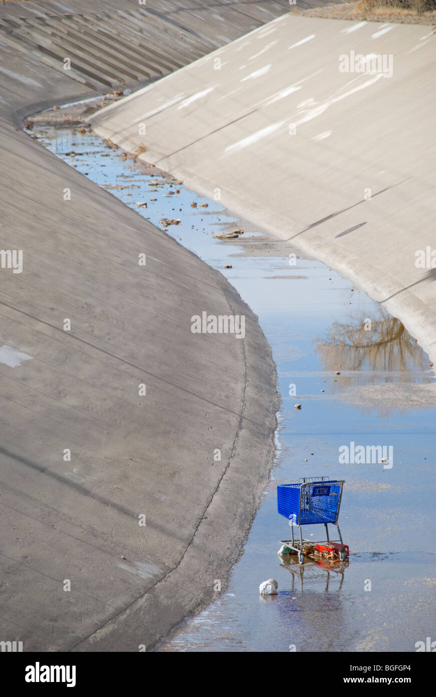 A grocery cart finds itself a new home among floating debris in the middle of an arroyo in Albuquerque, New Mexico. Stock Photo