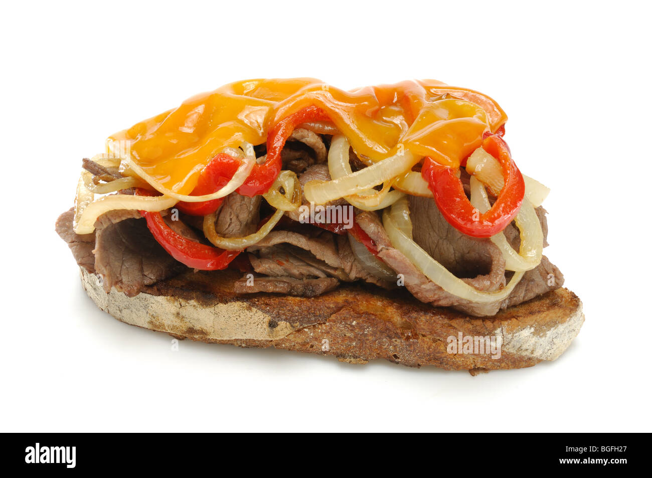 An opened faced meat sandwich with onions, red peppers and melted cheese on top Stock Photo