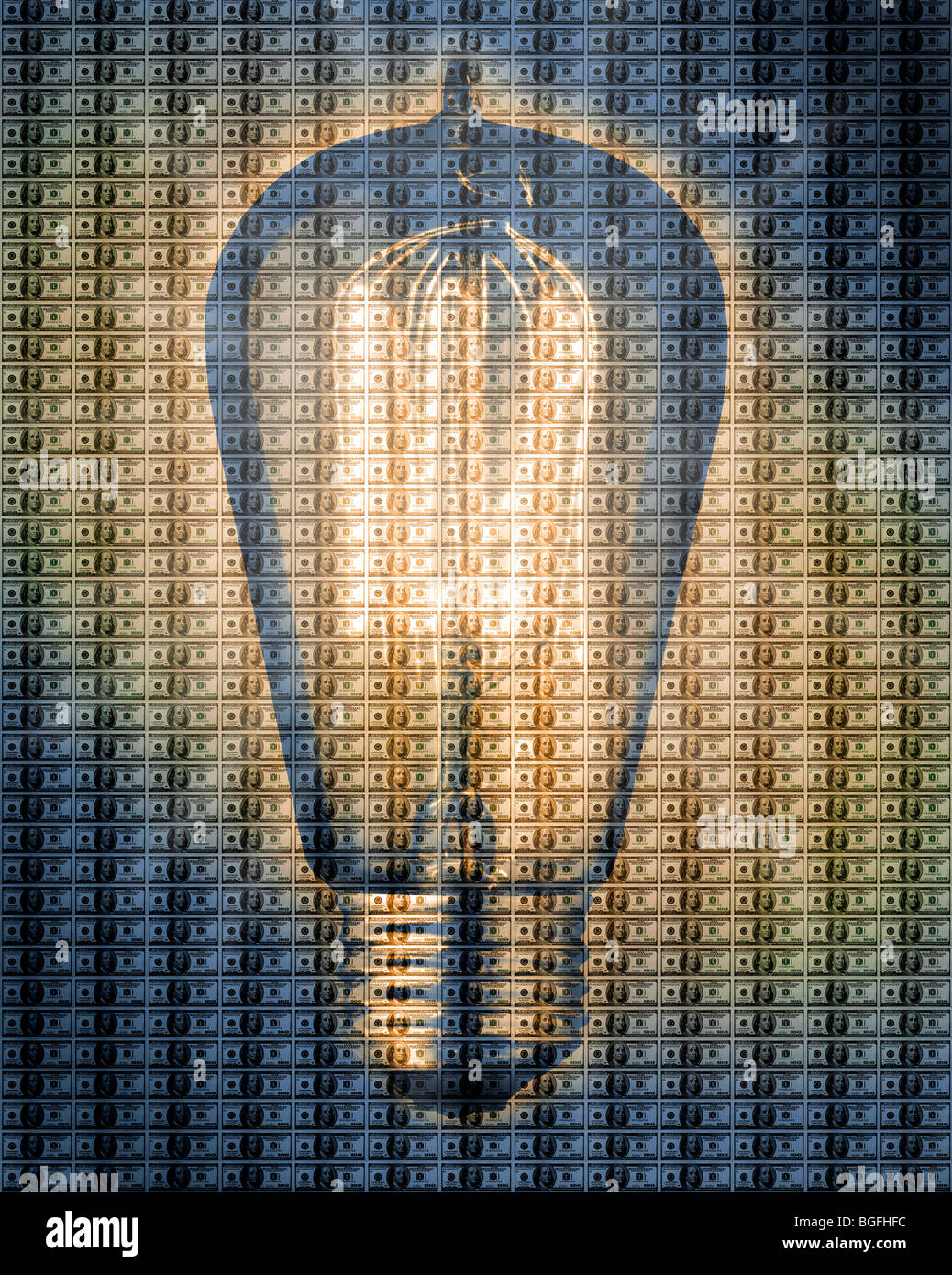 An old Edison style light bulb over a sheet of US Hundred dollar bills. Stock Photo