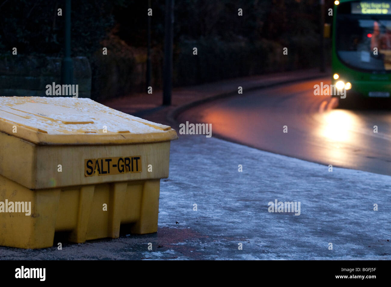 A salt grit bin at the road side of a busy street with traffic