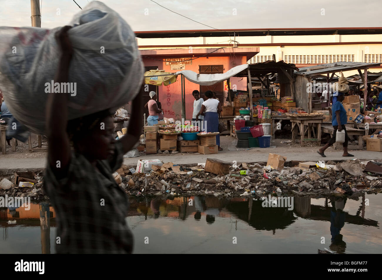 Street scene in Gonaives, Artibonite Department, Haiti, showing an incomplete drainage canal filled with rubbish. Stock Photo