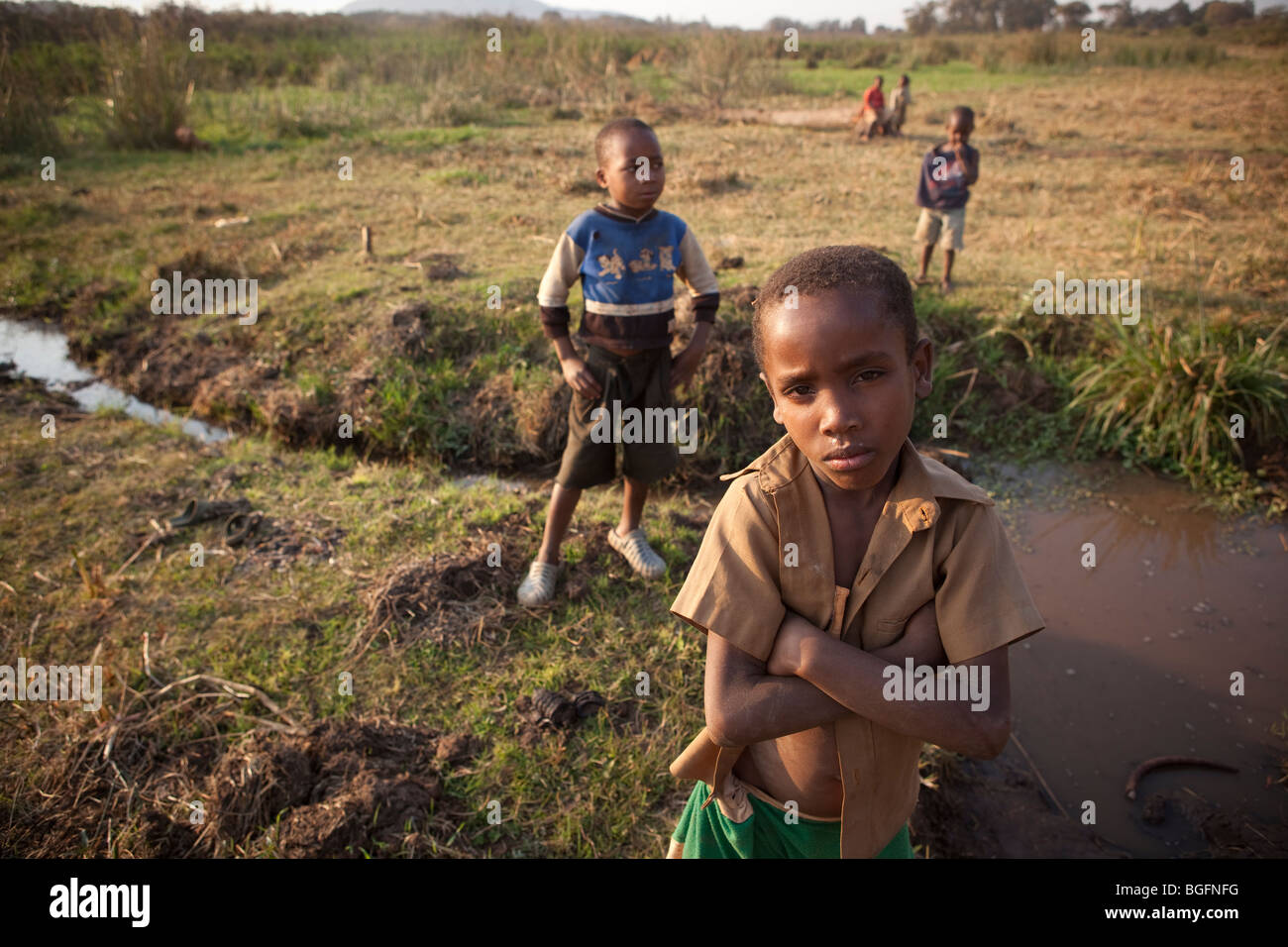 Children stand along a small creek near Lake Babati, Tanzania, East Africa Stock Photo