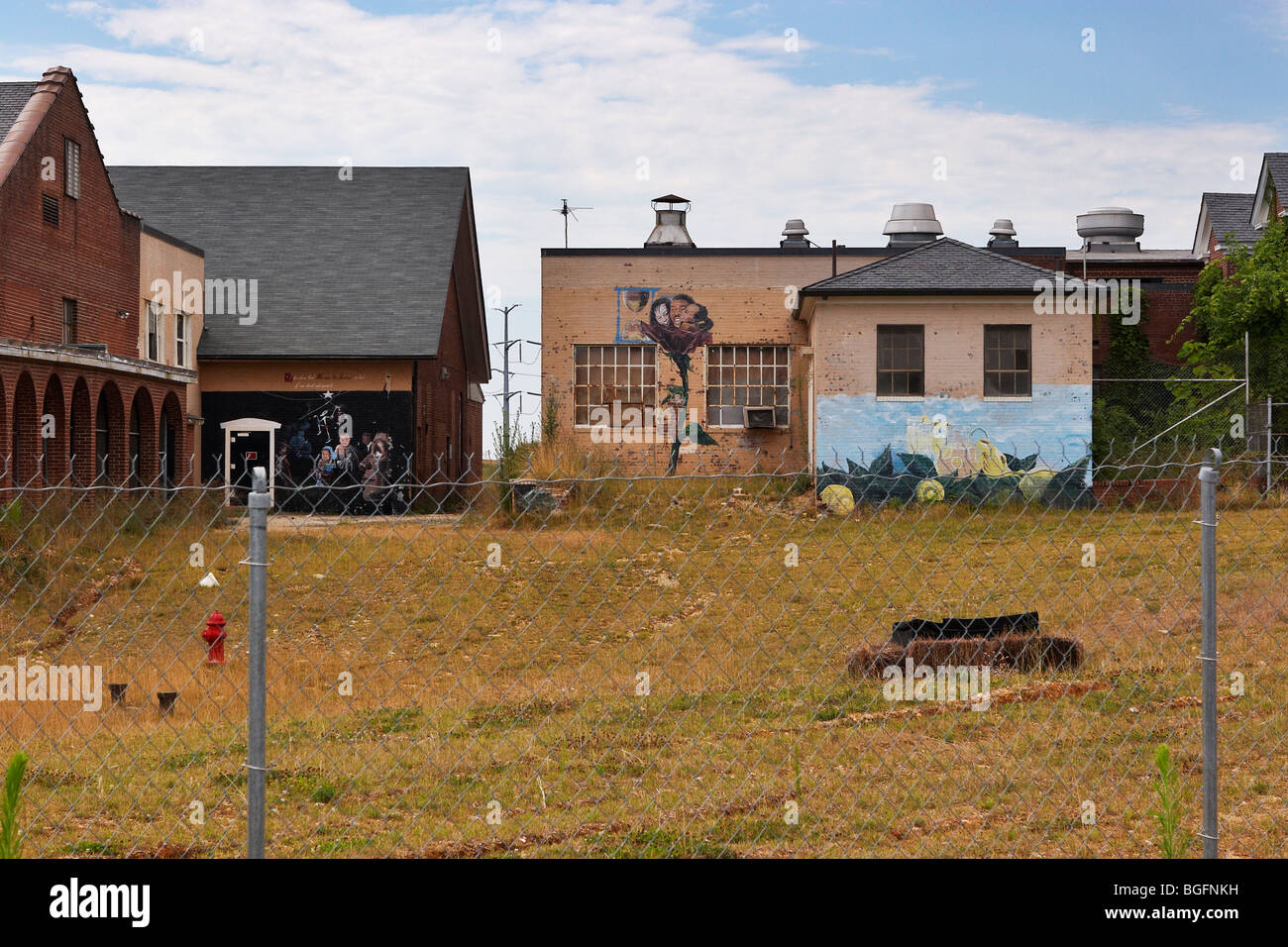 Buildings with painted murals behind a chain-link fence at the former Lorton Correctional Complex, Lorton, Virginia. Stock Photo