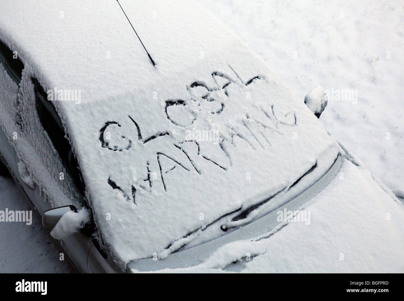 A snow covered car with the words Global Warming written in the snow in the big freeze of 2010 Stock Photo
