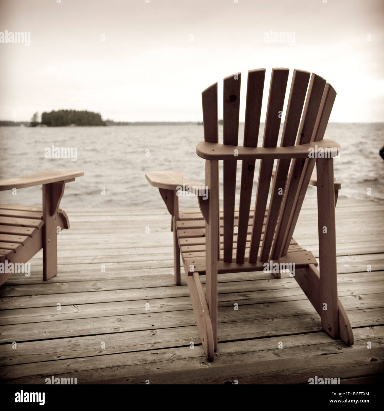 Dock and muskoka chairs on lake muskoka hires stock photography and
