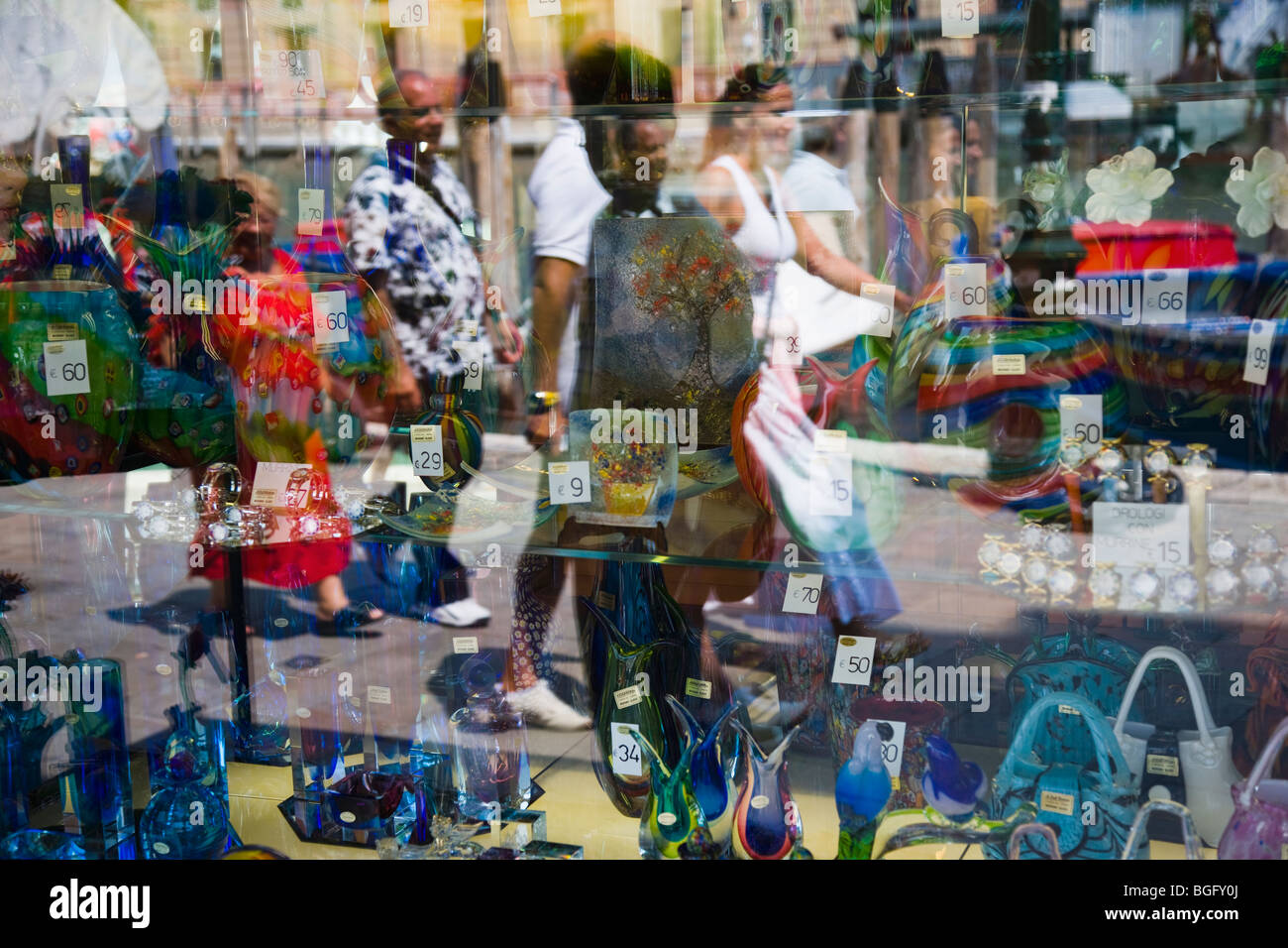 Murano glass store display window with people reflected, Venice, Italy Stock Photo