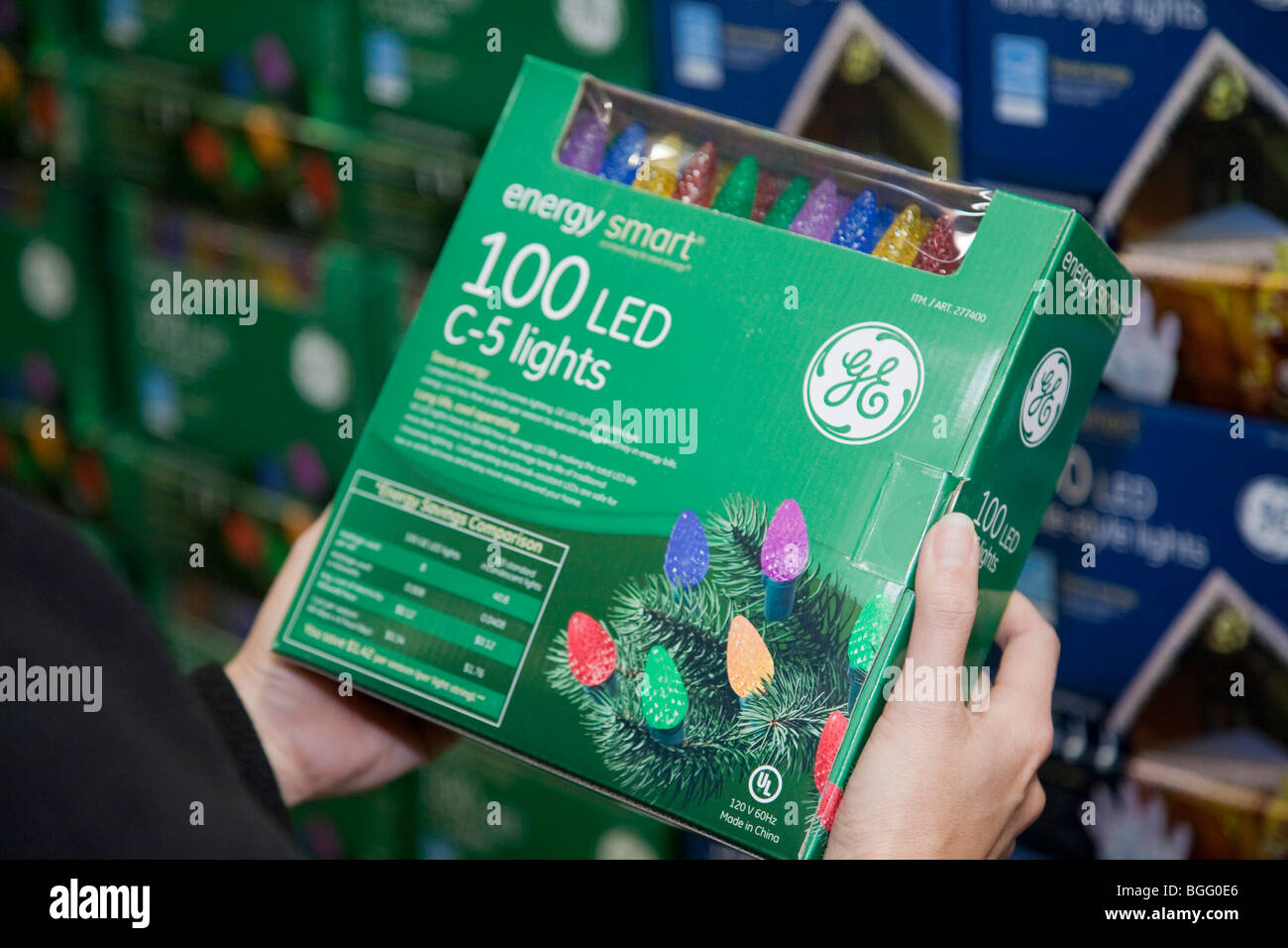 Woman holding sustainable holiday lights in store. General Electric
