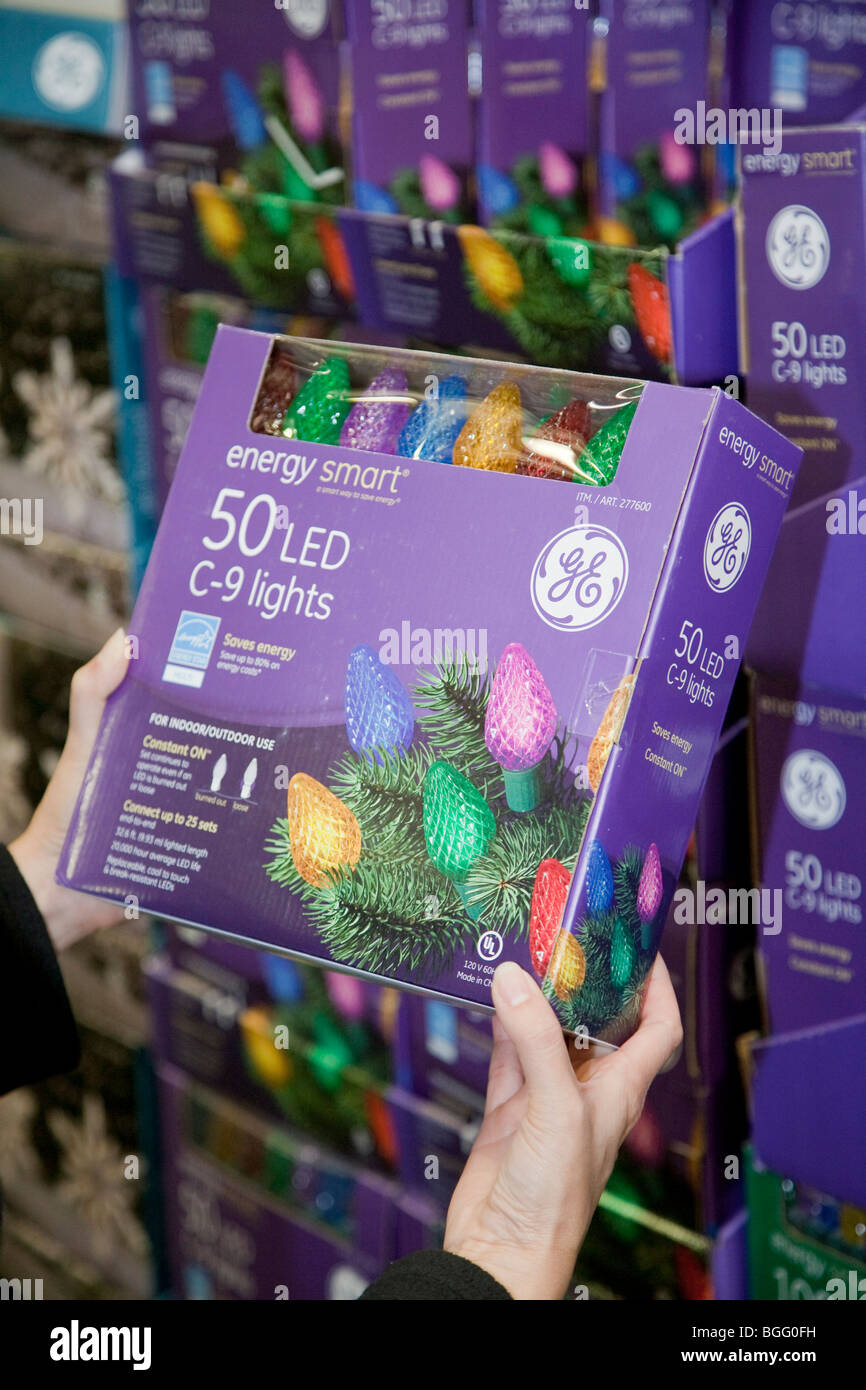 Woman holding sustainable holiday lights in store. General Electric brand 'Energy Smart' energy efficient LED holiday lights. Stock Photo