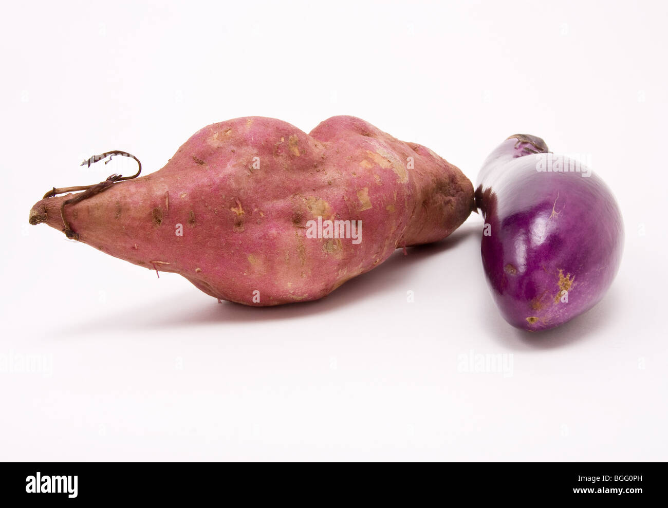 Sweet potato and Aubergine against white background from low perspective. Stock Photo