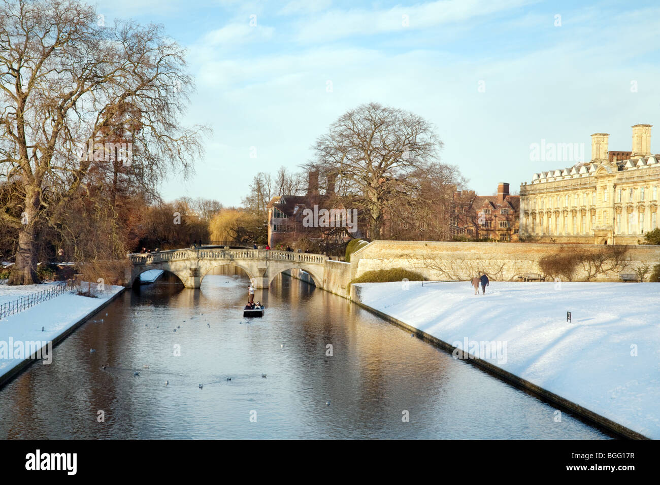 A lone punt with tourists on the river Cam in midwinter, Clare College, Cambridge University, UK Stock Photo