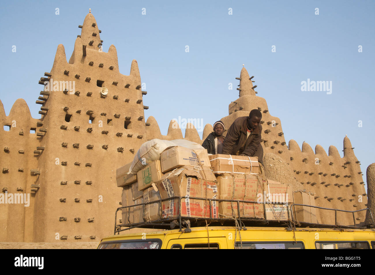 Traders unload their goods at the Monday market, infront of the great mud mosque, Djenne, Mali, West Africa Stock Photo